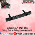Black guitar string guide retainer with 'Allparts' branding on a pink background