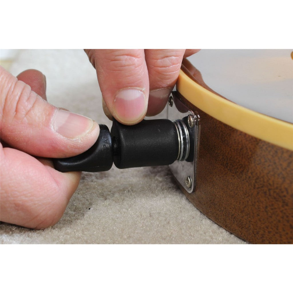 Close-up of a person's hands adjusting a black cylindrical clamp or strap component attached to a brown wooden object with a beige rim.