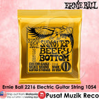 Ernie Ball Skinny Top Beefy Bottom electric guitar string package in a bright yellow pouch with black text and eagle graphic, shown on a pink background with product text overlays.