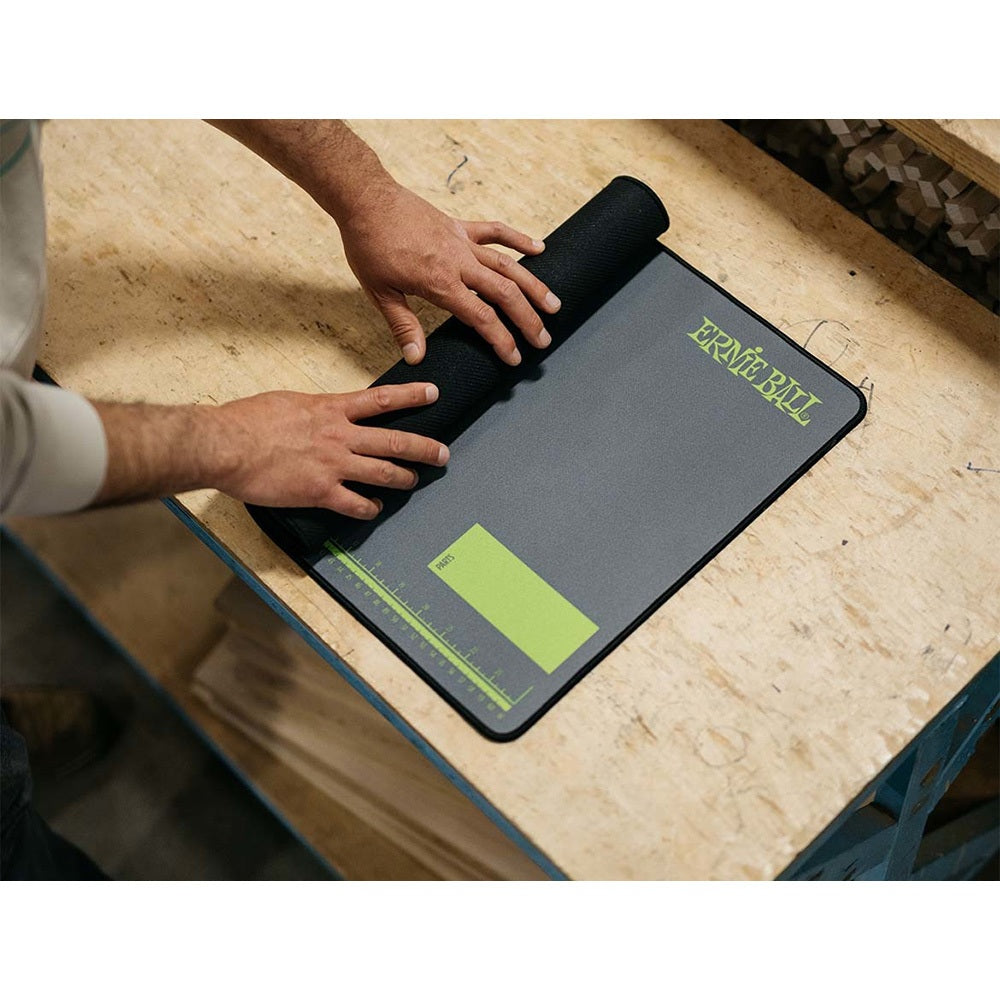 Person using a black and green desk mat on a wooden surface, with 'Erme Ball' branding.