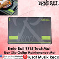 Ernie Ball 9615 TechMat non-slip guitar maintenance mat in dark gray with lime green accents, shown on a pink background with product text and a small inset photo of a hand using it.