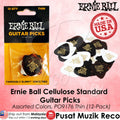 Ernie Ball Cellulose Standard guitar picks in a 12-pack, shown both inside their retail packaging and as a loose pile of assorted colors. The packaging is black and yellow, and the loose picks are a mix of black, white, and other colors printed with the Ernie Ball logo.