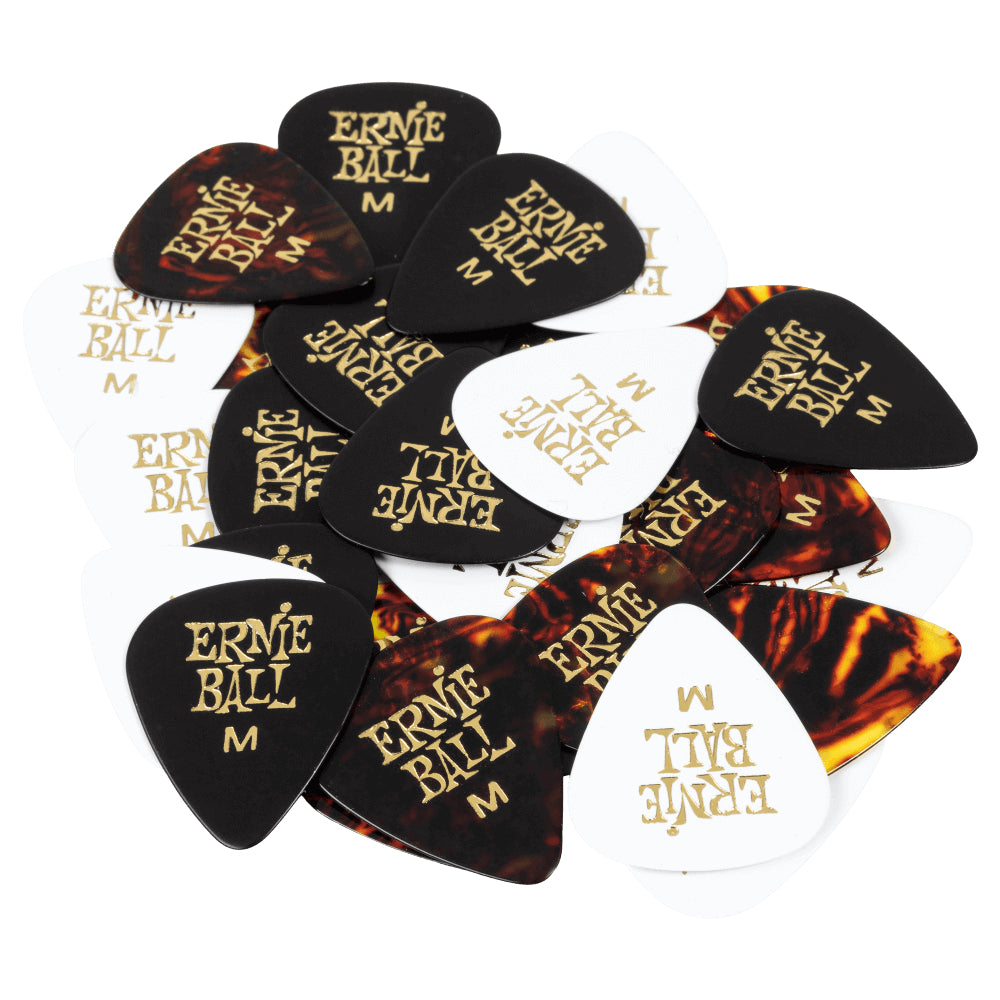 A pile of Ernie Ball electric guitar picks in black, white, and tortoiseshell patterns, each printed with the gold 'Ernie Ball' logo.