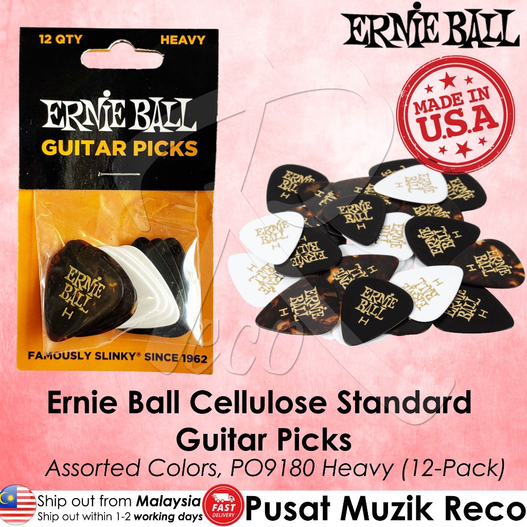 Ernie Ball heavy guitar picks in assorted black, white, and tortoiseshell colors, shown in their original retail packaging alongside a pile of loose picks on a pink background with product text and branding.