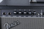 Close-up of a Fender amplifier with control knobs and branding.