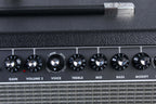 Close-up of a guitar amplifier with control knobs on a black background