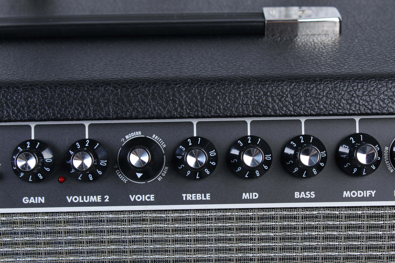 Close-up of a guitar amplifier with control knobs on a black background