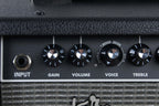 Close-up of a guitar amplifier with control knobs labeled 'Input', 'Gain', 'Volume', 'Voice', and 'Treble'.