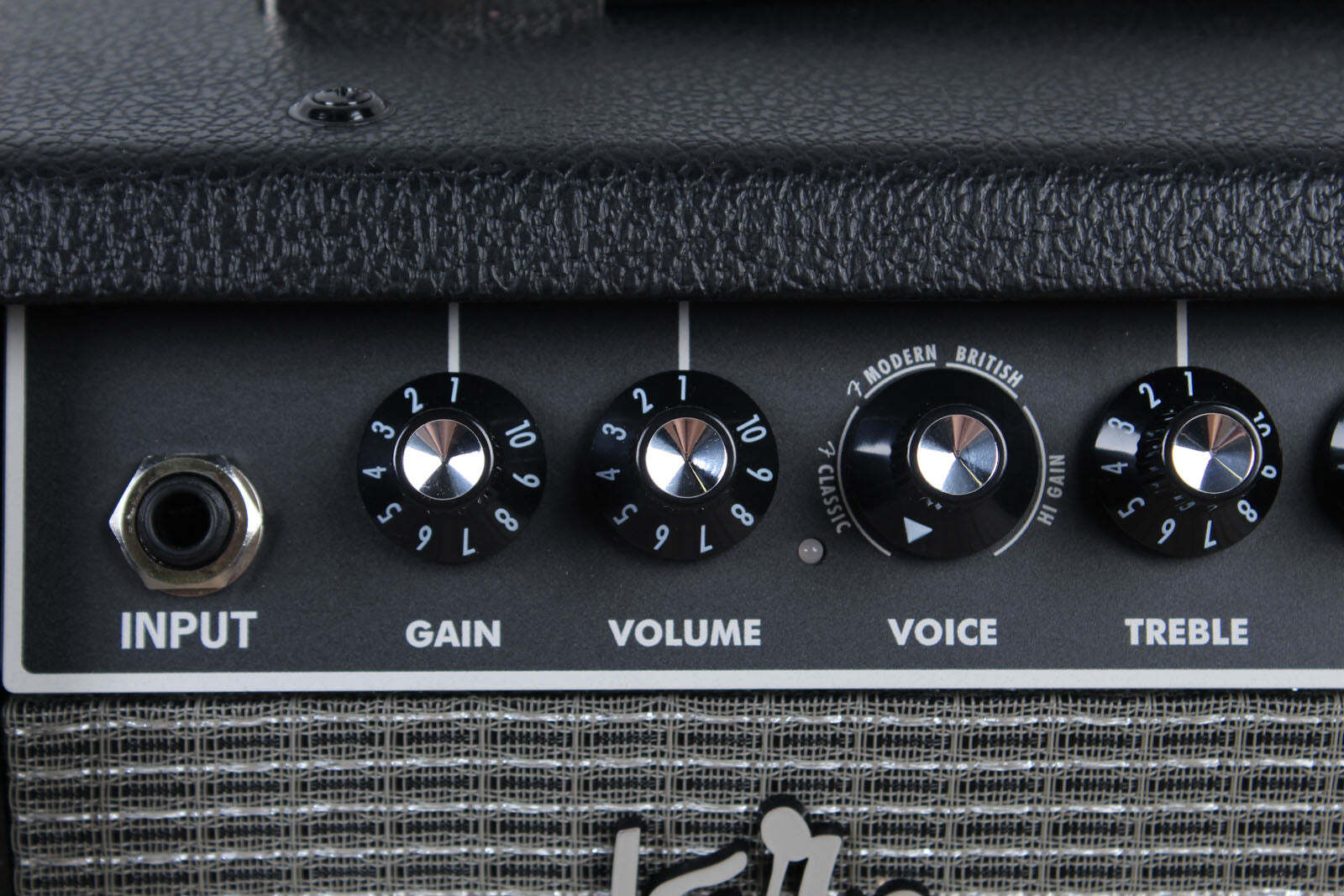 Close-up of a guitar amplifier with control knobs labeled 'Input', 'Gain', 'Volume', 'Voice', and 'Treble'.