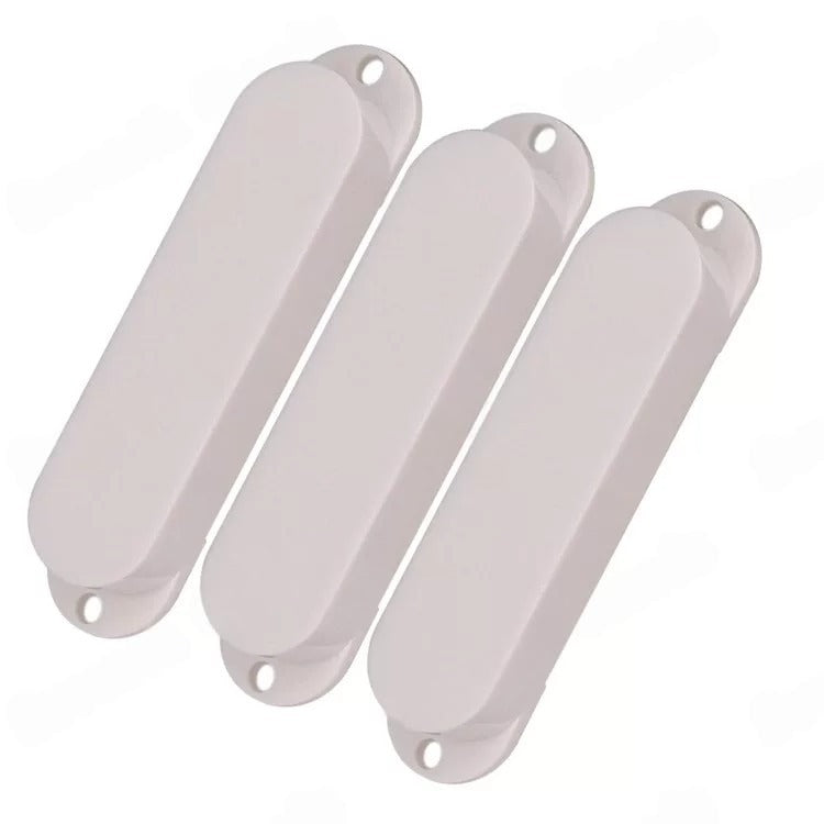 Three oval-shaped white plastic covers with mounting holes, arranged diagonally on a plain white background.