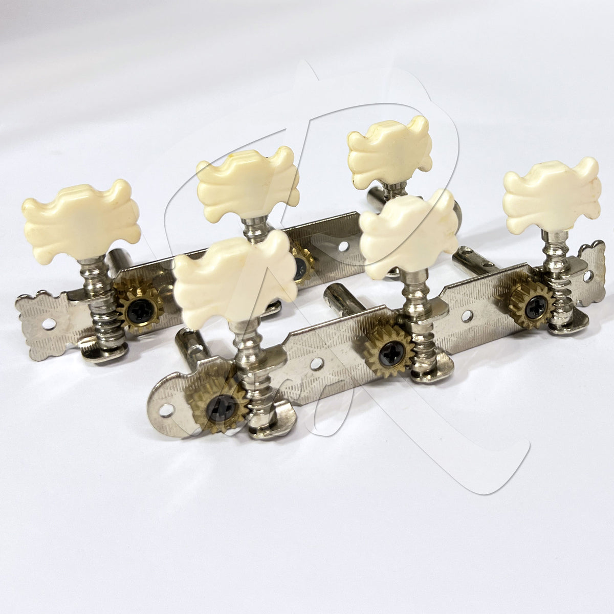 Four guitar tailpiece hardware units with cream-colored decorative knobs and silver metal bodies, arranged on a plain white background.