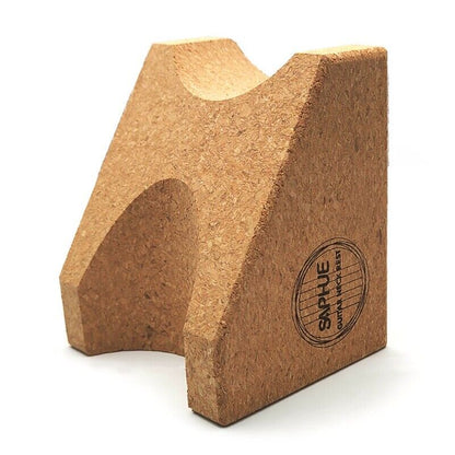 A natural cork bookend with a triangular shape and a circular 'SAPJUE' brand stamp on the side, set against a plain white background.