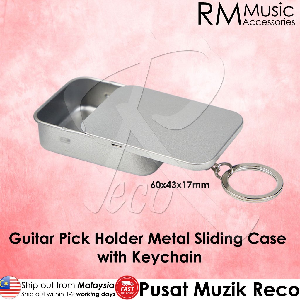 A silver metal guitar pick holder keychain case with a sliding lid and attached keyring, shown on a pink background with text overlays from RM Music Accessories and Pusat Muzik Reco.