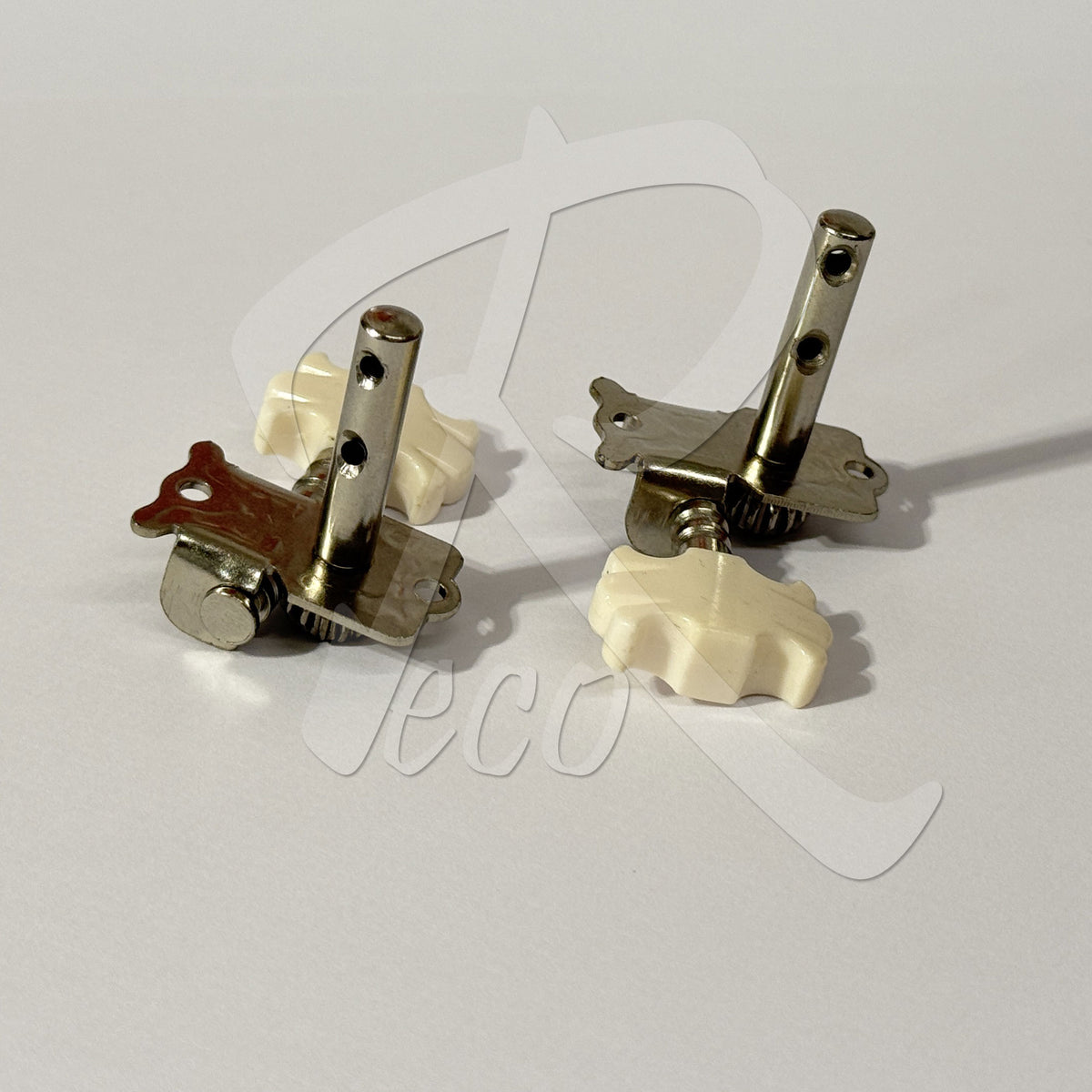 Two guitar tailpiece assemblies with cream-colored plastic knobs and silver metal hardware, displayed on a light gray background with a faint watermark.