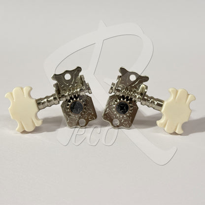 A pair of guitar tuning pegs with ornate silver metal bodies and cream-colored plastic knobs, displayed on a light gray background with a faint watermark.